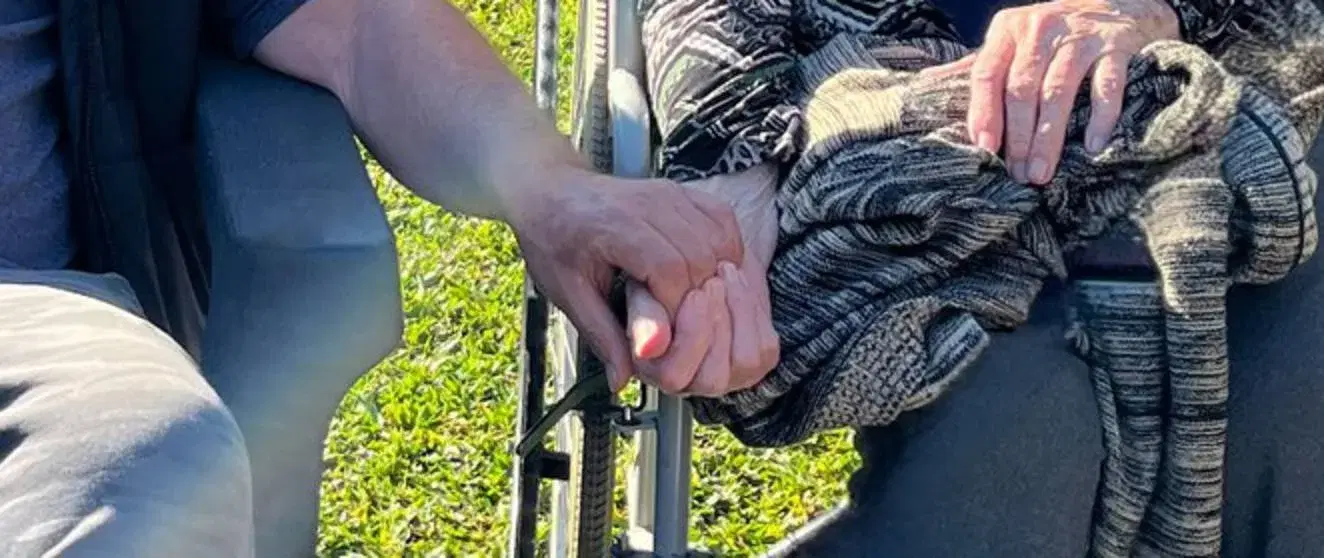 Un hijo toma la mano de su madre en el jardín