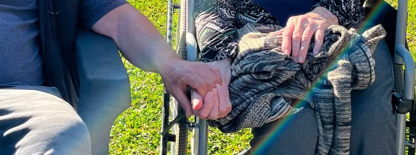 Manos de un hijo y su madre tomadas en el jardín