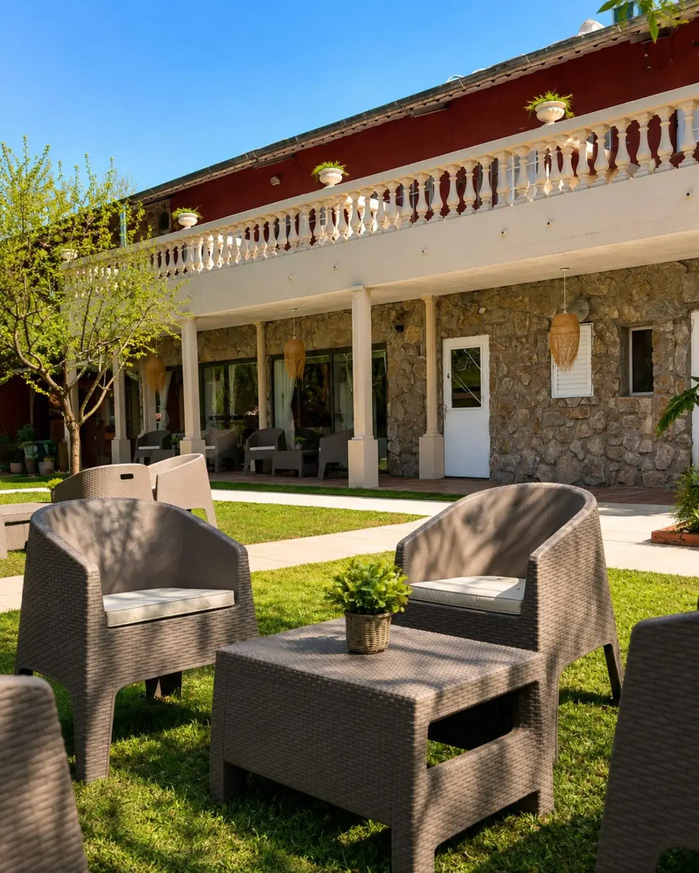 Sillones en el jardín frente a la galería de la residencia