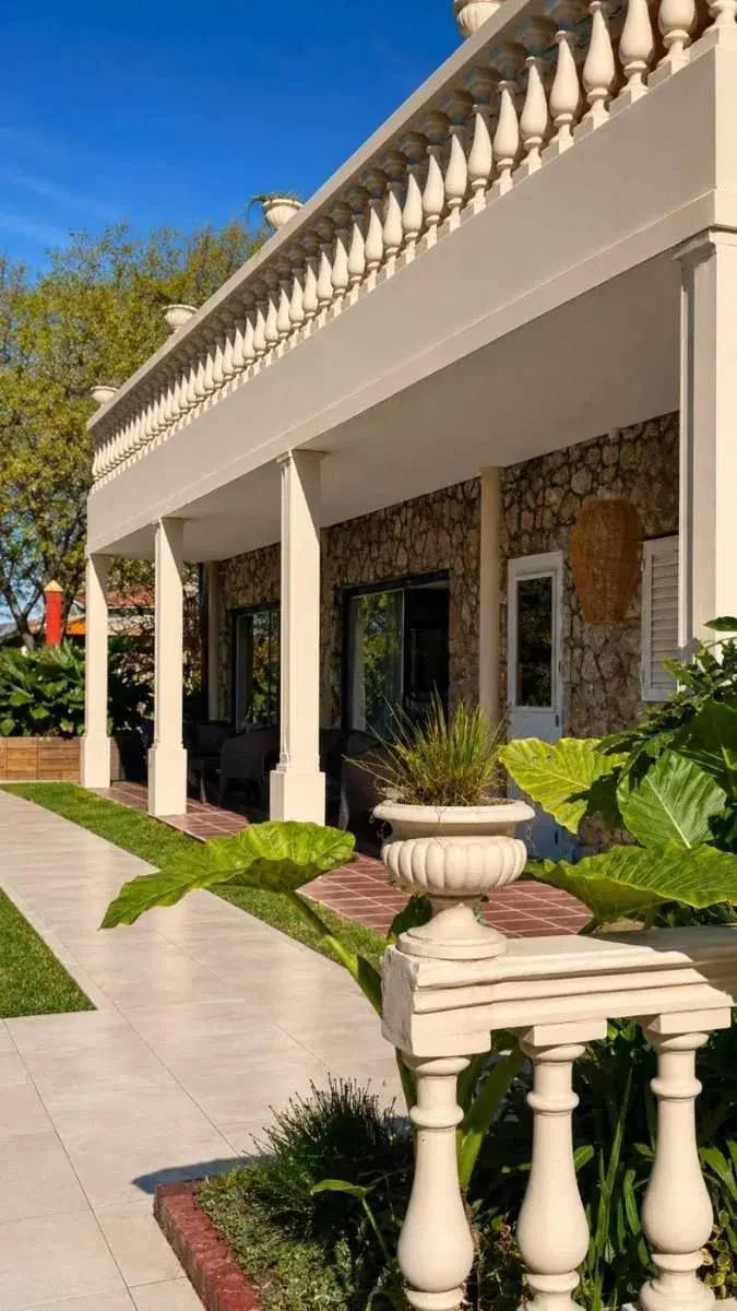 Galería con columnas y balaustrada frente al jardín